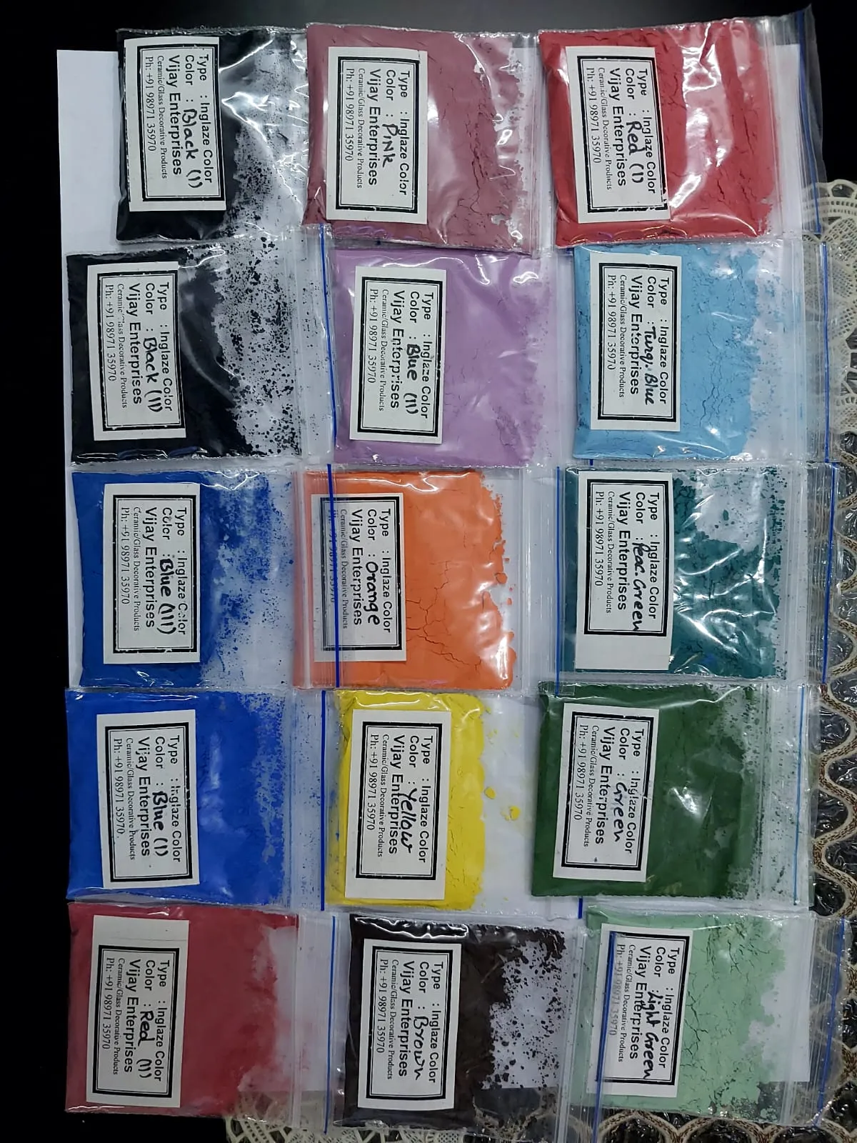 Sample packets of ceramic colours, each labelled with shade and code